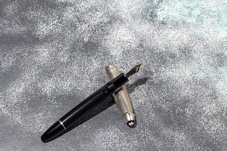 Fountain pen on a marble and gray background. Selective focus.