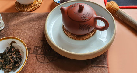 tea ceremony. Chinese pu-erh in a bowl. In the background is a brown teapot and tea leaves. copy...