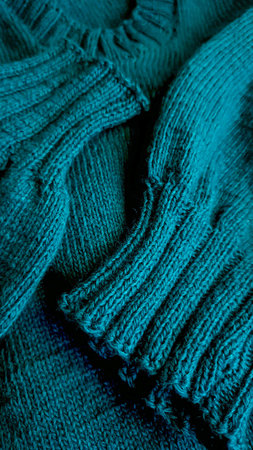 Knitted handmade products. Knitted fabric of colored threads in the color of petrol.
