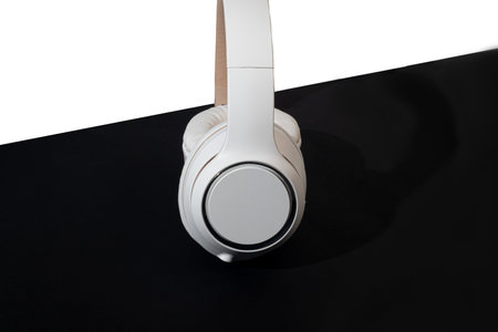 Beige wireless headphones on a dark background. isolate. Accessory for listening to music. copy...