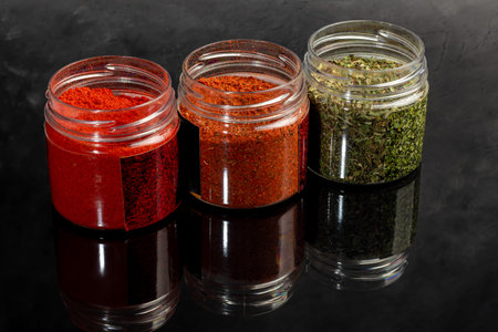 Variety of spices on a dark background in a glass bowl. Enhancement of taste. copy spaceの写真素材