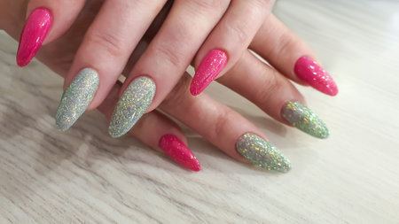 Acrylic nail extensions, manicure, nail correction, hands in the foreground. Reflective design.の写真素材