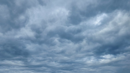 Blue sky with clouds, winter weather. Clouds on the background of trees. Blue and gray shadesの写真素材