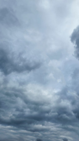 Blue sky with clouds, winter weather. Clouds on the background of trees. Blue and gray shades