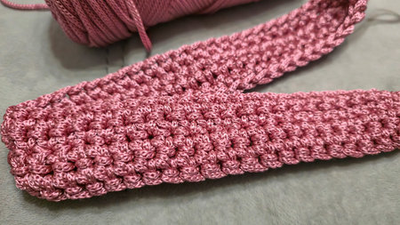 Knitting elements of a pink women's bag, hand knitting with a long handle. Step-by-step...