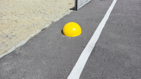 Hemispherical yellow concrete stop stone on asphalt. No entry.の写真素材