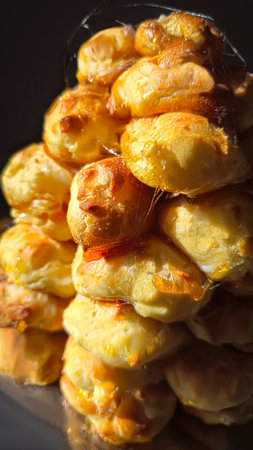 Croquembouche on a light plate covered with caramel. Eclairs with homemade custard cream. Homemade pastriesの写真素材