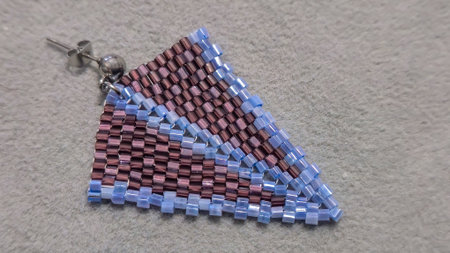 Handmade beaded and glass bead earrings on a light background. Product demonstration. Fashion...