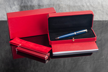 A fountain pen on a gray marble background. A box and case are nearby. A gift set. Office interior.の写真素材
