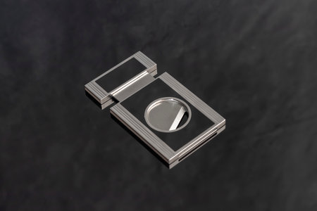 A gray metal guillotine with a sharp cigar cutter on a dark background. Smoking accessories.の写真素材