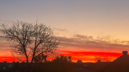The red-crimson and orange evening sky over the city. Fiery sunset.の写真素材