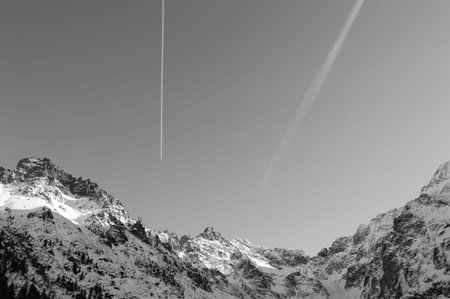 Frozen mountains with snow and clear sky with small plain and cloud
