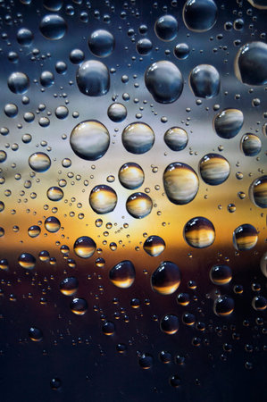 Raindrops with true golden hour sunset with blue, gold and dark colorsの写真素材