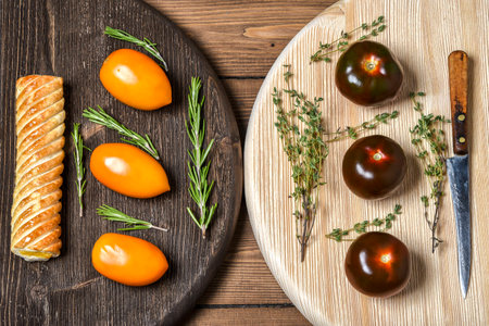 Yellow and black tomatoes on wooden Boardの写真素材