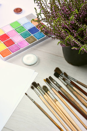 White sheet, paint brushes, paint flower on the tableの写真素材