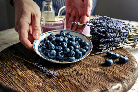 Blueberries on a saucer, lavender, pitcher. male handsの写真素材