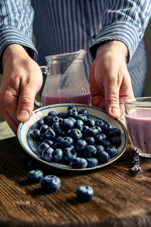 Blueberries on a saucer, lavender, pitcher. male handsの写真素材