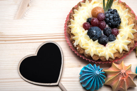 Black plate for text, a cream cake with berries, meringueの写真素材