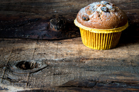Cupcakes on an old textured Board. Dusted with powdered sugarの写真素材