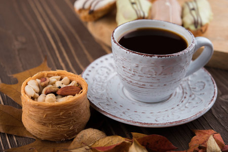 Cup of coffee, Oriental sweets, nuts, cakes, red autumn leavesの写真素材