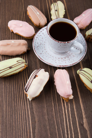 Cup of coffee and colorful cakes on wooden backgroundの写真素材