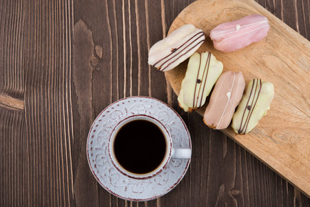 Cup of coffee and colorful cakes on wooden backgroundの写真素材