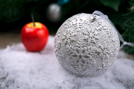 Christmas ball in the snow, behind a decorative Appleの写真素材