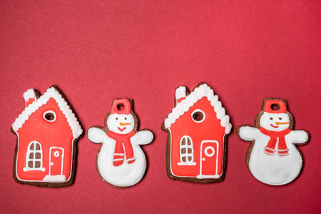 Gingerbread cookies on red background, snowman, gingerbread houseの写真素材