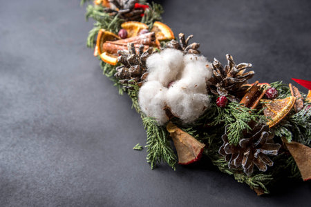 Christmas wreath of cones, lemons, cinnamon and berriesの写真素材
