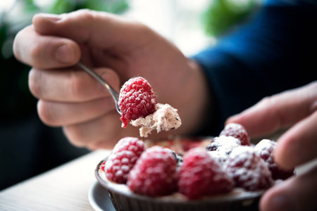 Man in a cafe eating berry cake, smoothies from berriesの写真素材