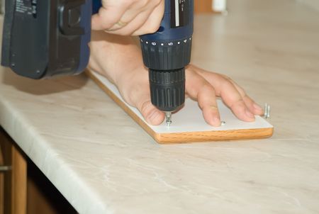 Assembling sectional kitchen furniture using a screwdriver machine.の写真素材