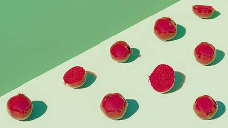 3d rendered red pomegranates on green backgroundの写真素材