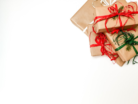 Four Christmas gift boxes crafted and red and green ribbons on a white background, space to insert, text, top viewの写真素材