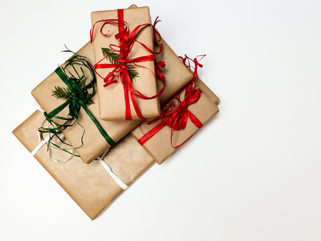 Four Christmas gift boxes crafted and red and green ribbons on a white background, space to insert, text, top viewの写真素材