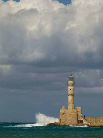 White waves with a lot of spray are beating on the lighthouse in Chania under a gloomy sky, Creteの写真素材