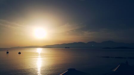 Dawn on the sea, in the distance on a background of mountains a cruise liner is sailing, Crete, Greeceの写真素材
