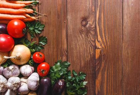Vegetables and greens on a wooden table. Plant foods for the elderly. Vegan table. View from aboveの写真素材