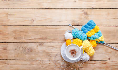 Yarn in warm colors on a white wooden board. Yellow, blue, beige, white and green. The beginning of the process of knitting a women's sweater. Female hobbies, knittingの写真素材