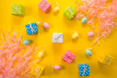 Easter holiday background. Pastel colored decorated easter eggs on a bright yellow background.の写真素材