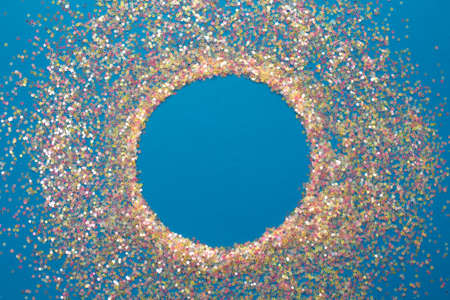 multicolored confetti on a blue background top view.の写真素材