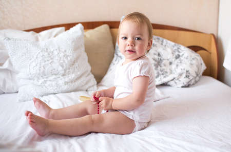 little cute girl playing in bed laughing and smiling.の写真素材