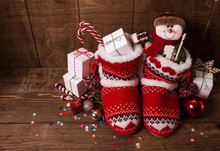 Little knitted boots with christmas presents and various cookies.の写真素材
