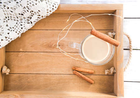 Traditional winter eggnog in glass mug with milk, rum and cinnamon, christmas decorationsの写真素材