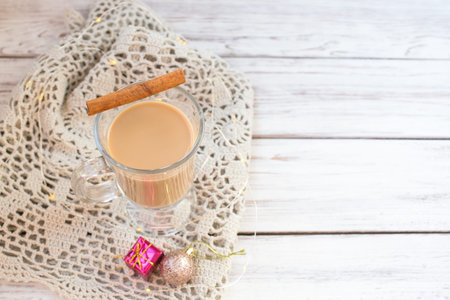 Traditional winter eggnog in glass mug with milk, rum and cinnamon, christmas decorations