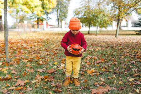 a girl stands in the Park with a pumpkin in her hands.