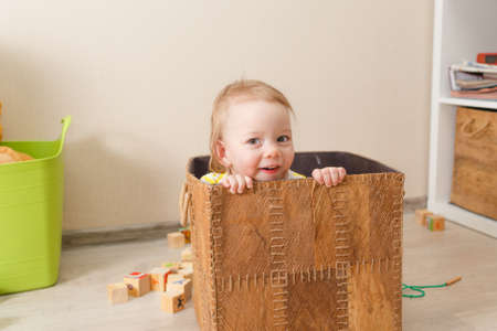 beautiful little child plays with wooden cubes. Kid playing on the floor in the childrens roomの写真素材