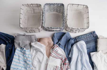 Many colorful clothes are lying on the floor. baskets for folding clothes. The view from the top.の写真素材