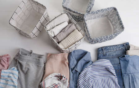 Many colorful clothes are lying on the floor. baskets for folding clothes. The view from the top.の写真素材