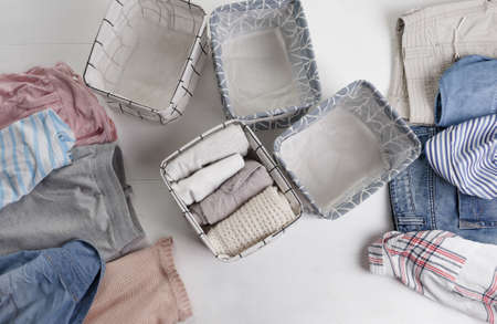 Many colorful clothes are lying on the floor. baskets for folding clothes. The view from the top.の写真素材