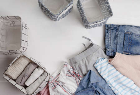 Many colorful clothes are lying on the floor. baskets for folding clothes. The view from the top.の写真素材